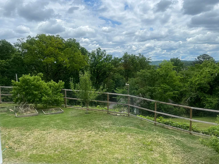 View of large fully fenced yard from the large porch off of living room.