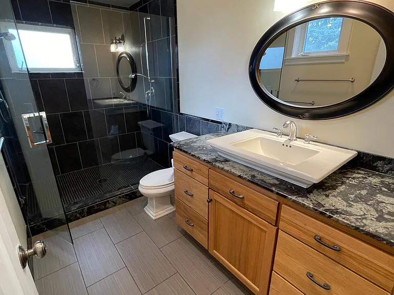 Primary en suite new tile step-in tile shower for two with two adjustable shower heads and additional cabinet storage in dressing space outside en suite bathroom.