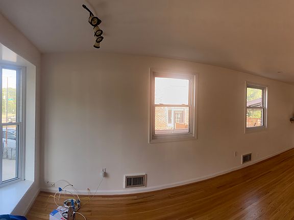 Open concept living/dining room with breakfast bar between kitchen and dining and beautiful bay window