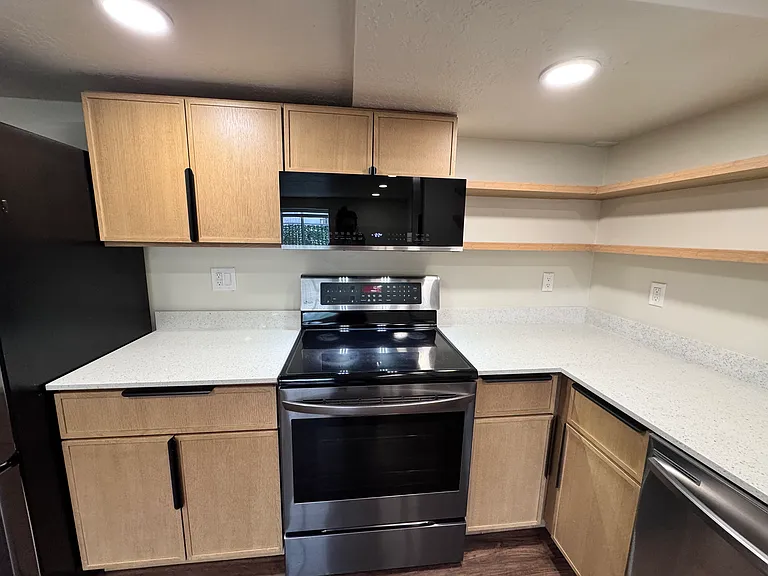 Bright kitchen with modern cabinetry, open shelves, and generous countertop space_ideal for everyday use.