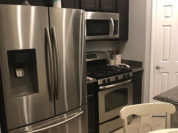 Kitchen with stainless steel refrigerator, stove and built-in microwave.