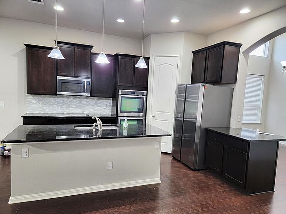Open kitchen with island, 2 ovens, microwave, refrigerator, dishwasher and walk-in pantry. Lots of cabinet space for storage.
