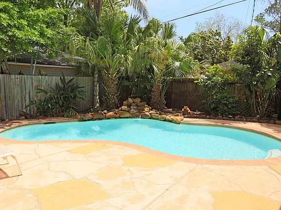 A lushly landscaped and welcoming backyard plays host to a leisurely pool and patio area, perfect fo