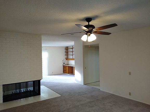 Living Room to Den & 3-sided wood/gas fireplace.