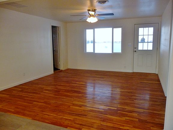 Living room with beautiful hardwood flooring & ceiling fan 