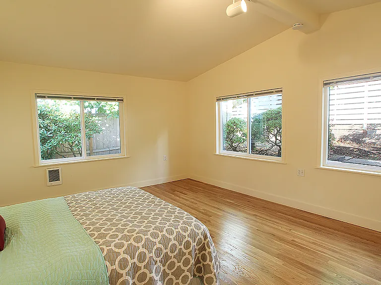 Primary bedroom with 3/4 bath and ductless heat pump. Windows face North and West. Dimensions approximately 13ft x 16ft excluding closet and bathroom.