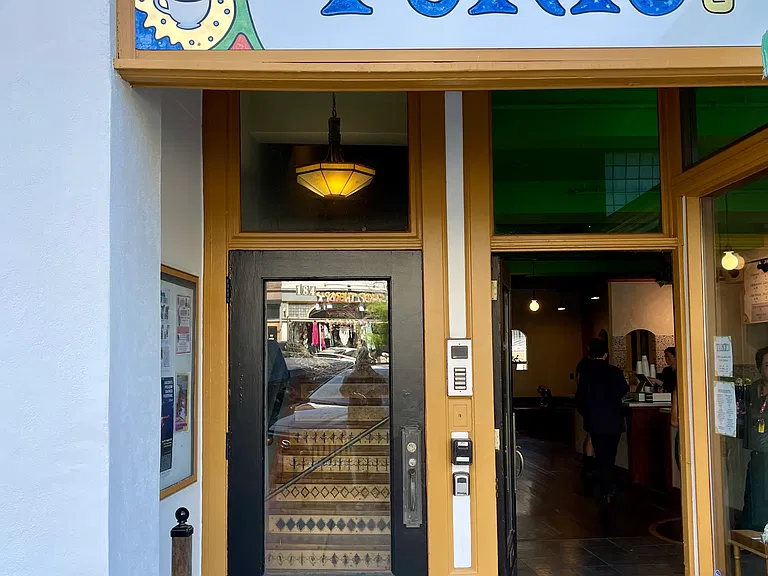 The door to the building is next to Tunic's front door.