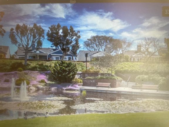Lake with water fountain surrounded by walking trails
