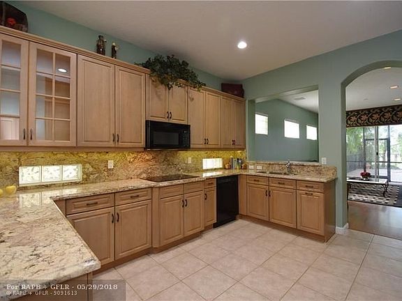 Massive gourmet kitchen with granite counters and back splash  and cabinet lighting and pass-thru to family room.