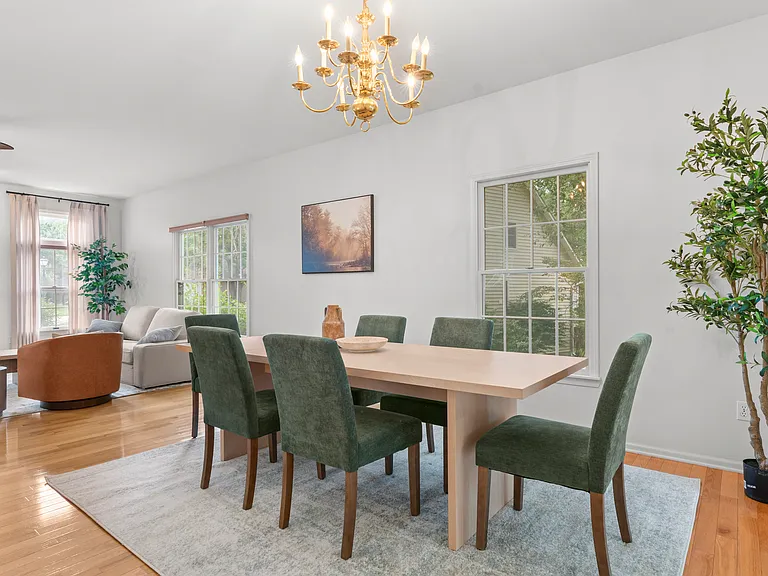 Spacious dining area with a large dining table and comfortable chairs, conveniently connected to the kitchen and sunroom.