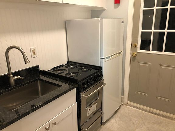 Updated kitchen includes new floor, base cabinet, gas stove, faucet, and granite counter-tops