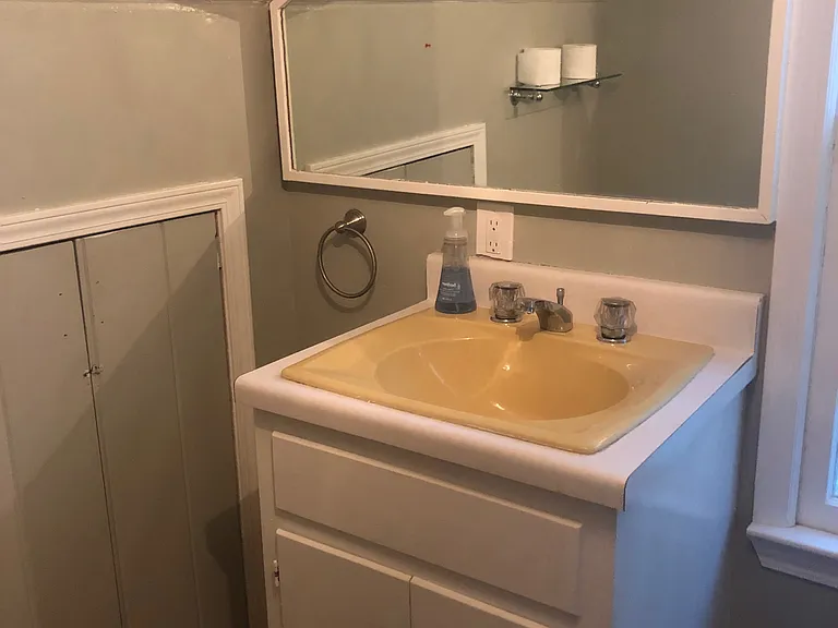 Bathroom sink and mirror - window located beside sink lets in plenty of natural light