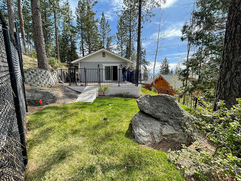 Fenced yard with well-maintained lawn, trees, and shrubbery serviced by automatic sprinkler and drip system; granite accents