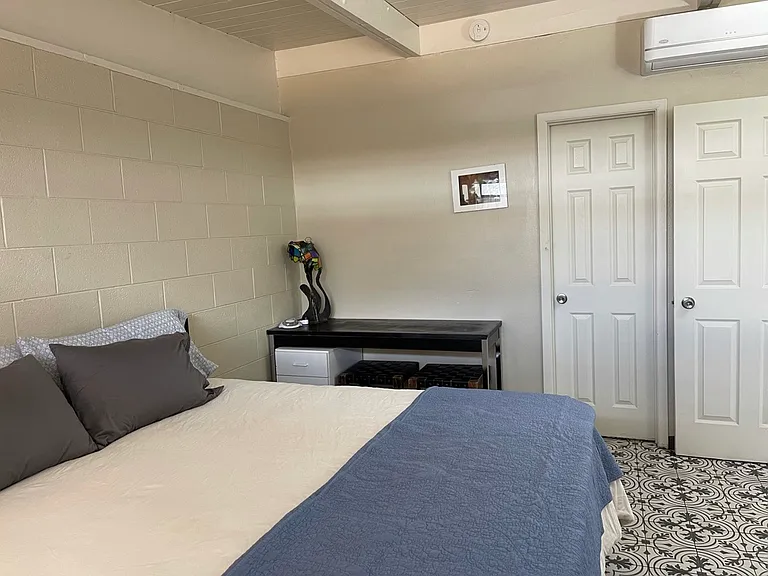 First bedroom with desk and Ductless heater/air-conditioner unit, and work desk.