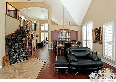 Decorative Central Staircase + Rich Hardwoods & Travertine Floor