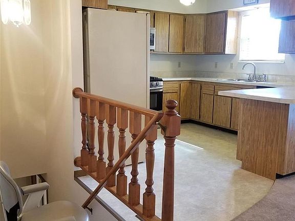 Banister leads to finished lower level. Stair lift is an added convenience, can be removed if Buyer does not want the lift on th