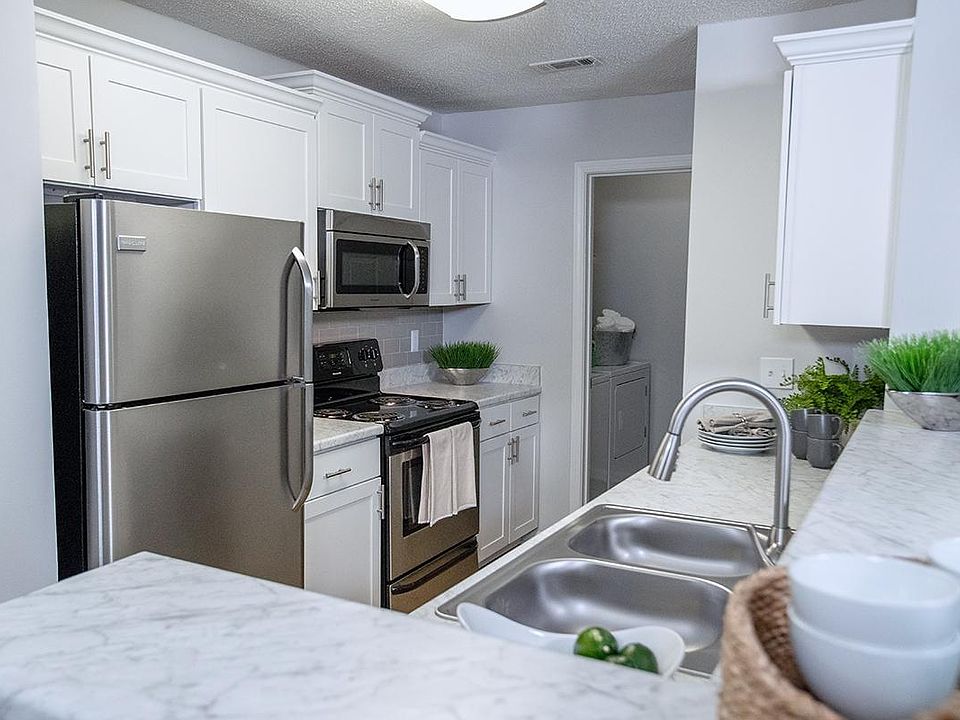 Newly renovated kitchens featuring white marble-style countertops, wood-style flooring, stainless steel appliances, and a breakfast bar.