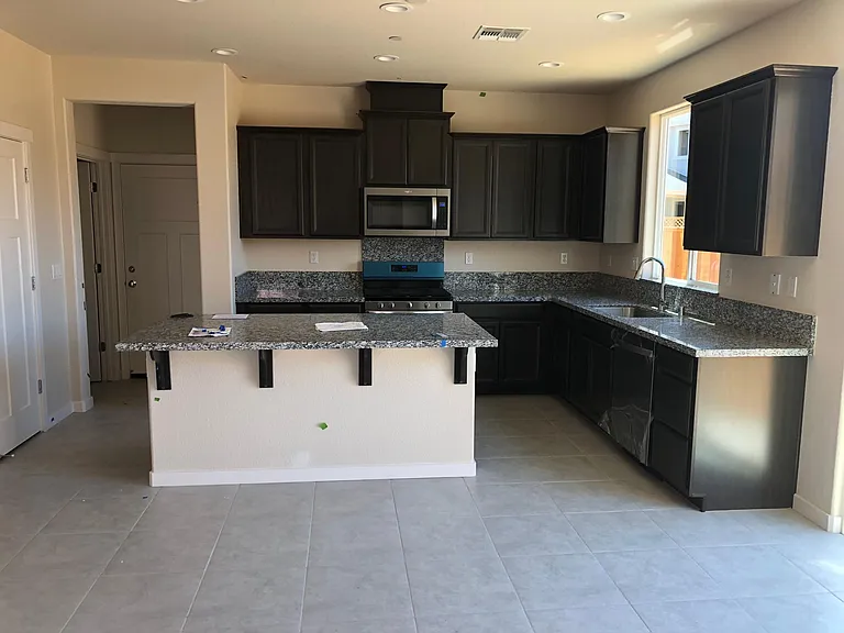 View of kitchen and dining area from front door, door views for garage , downstairs bathroom and pantry