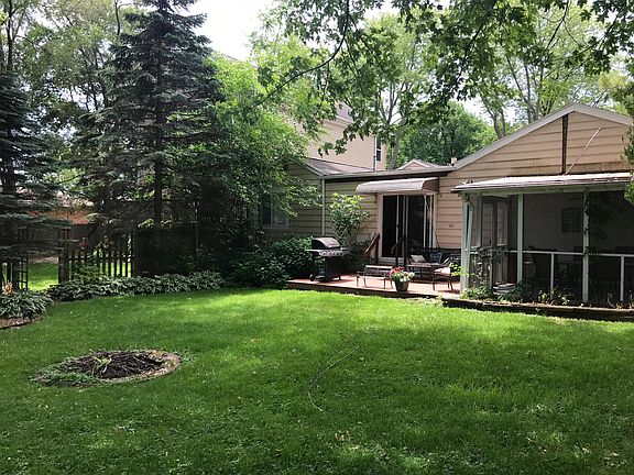 Backyard w screened in porch fire pit deck and grill