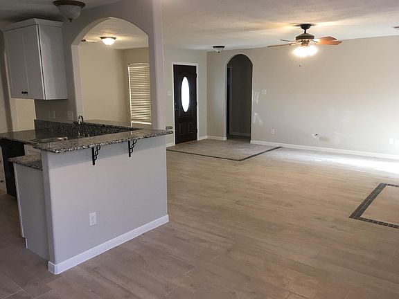 Looking from the dining area to the living area and front door. Notice the cute arched theme.