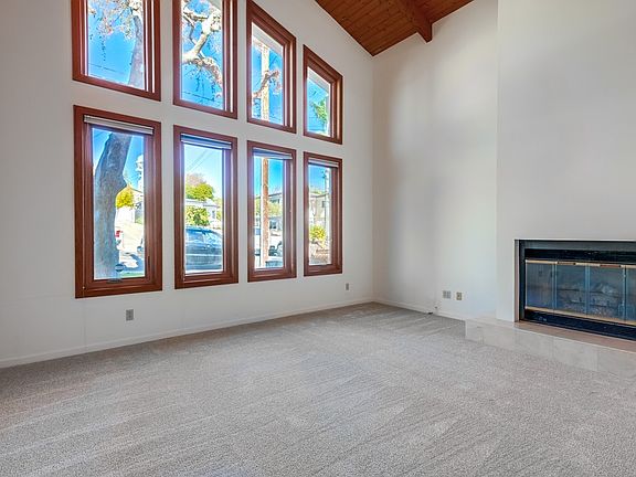 Large living room with cozy fireplace and view into the neighborhood