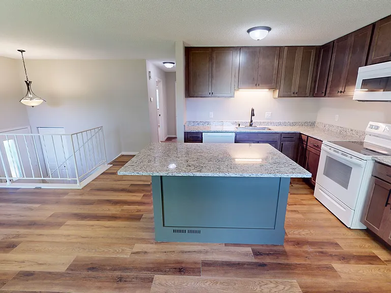 Kitchen view featuring new cabinetry, countertops, and updated flooring.
