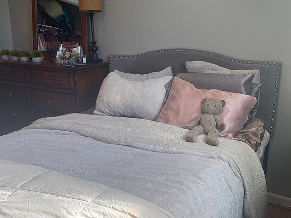 Primary bedroom fits a queen size bed, side table, dresser and dressing/makeup table. Also features built ins