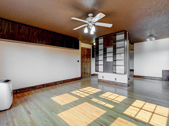 Living room has plenty of open and closed shelving and storage.