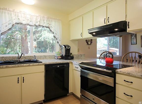 Enter the kitchen with newer appliances, real wood cabinets, a pantry and view to the breakfast nook.