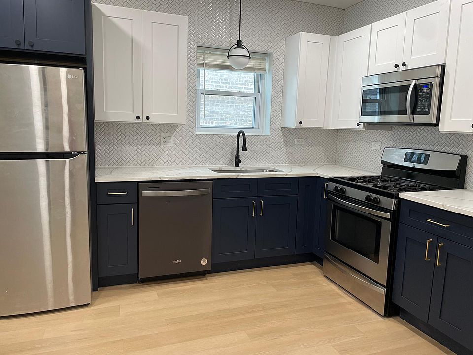 White upper cabinets and navy blue base cabinets with gold hardware pulls
