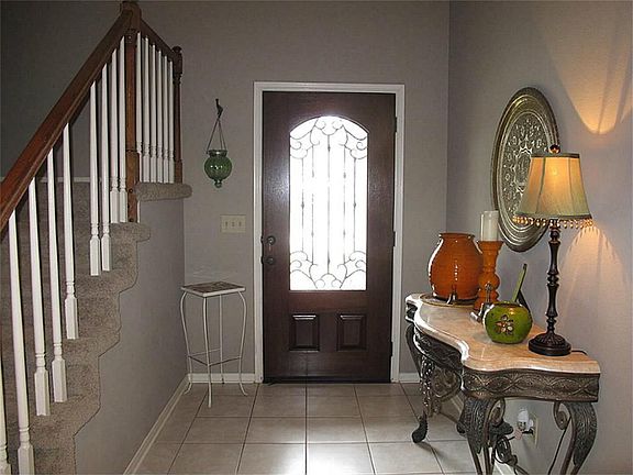 Beautiful entry with gorgeous wood & glass front door & tile flooring