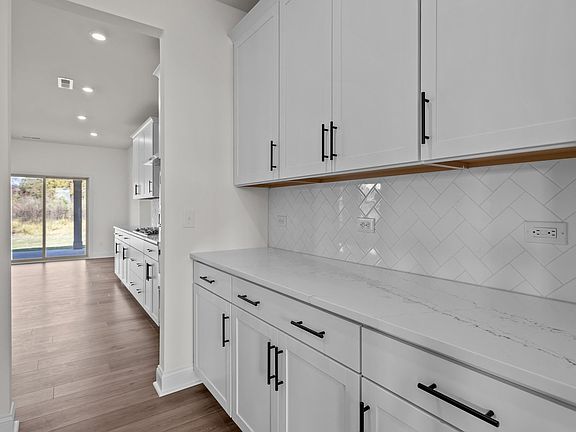 Norris Design pass-through butler s pantry with abundant cabinets. At Lakeside Glen by DRB Homes in