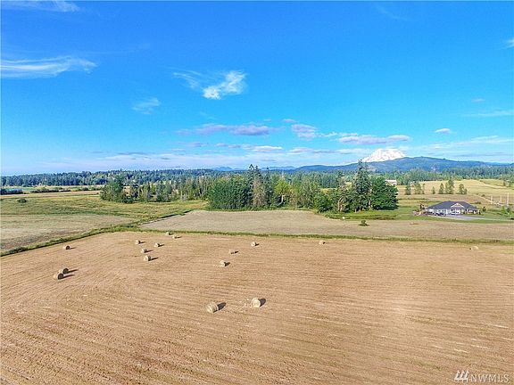About have of the 10 acres is pasture, this is a view of it being hayed. Front of the house and Mt in the back ground. 