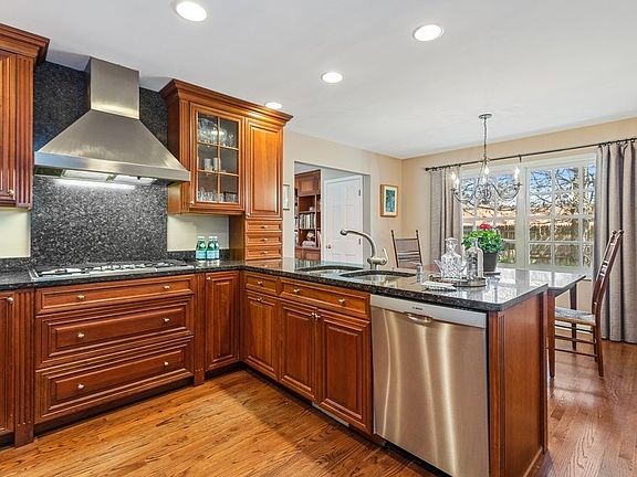 Open to a sunny breakfast room and family room beyond