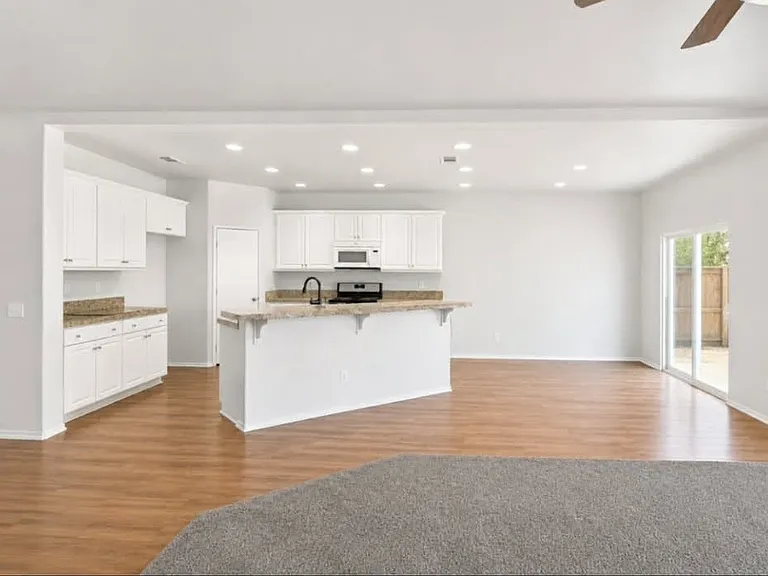 Spacious kitchen featuring a large center island, ample cabinets, and granite countertops.