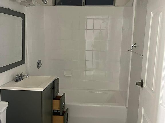 BATHROOM WITH TUB/SHOWER COMBO. VANITY MIRROR AND CABINETS FOR EXTRA STORAGE.
