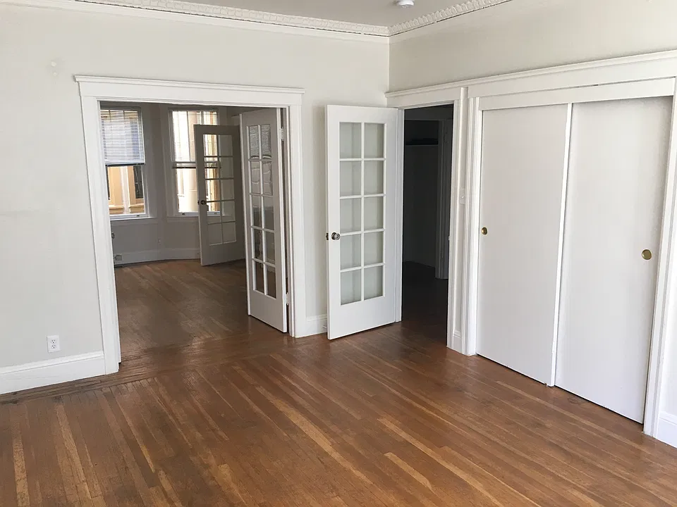 LR/BR with sliding door closet, doorways to BR/LR (left) and hallway (right)