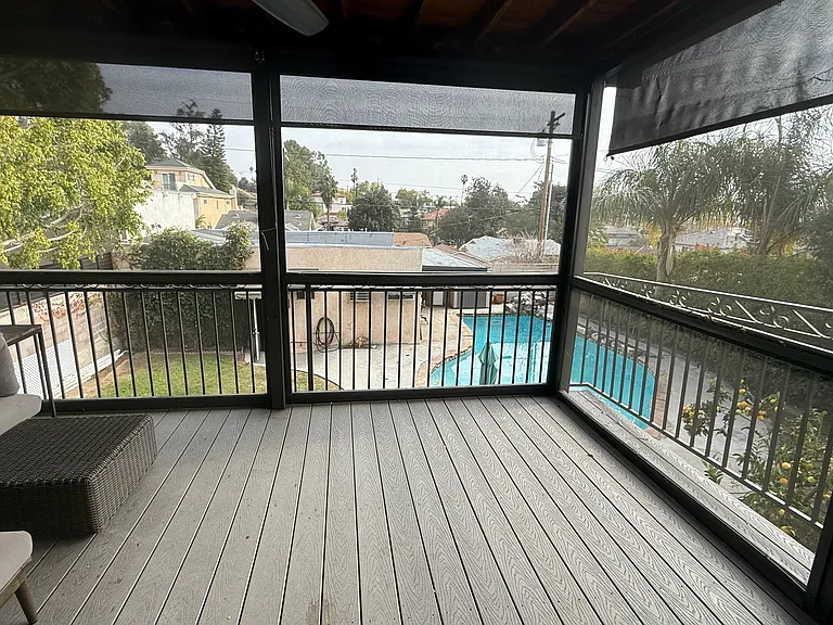 Screened in balcony off kitchen area overlooking backyard pool. West Elm patio lounge. Privacy / Sun screens