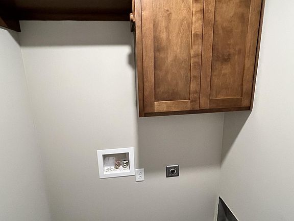 Laundry room with storage cabinet and rod and shelf