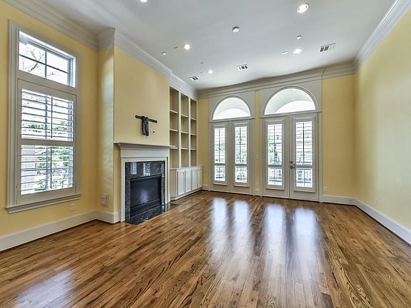 Living Room has beautiful arched windows, hgih ceilings, and gleaming hardwoods. The fireplace is the staple of this sophisticated space.