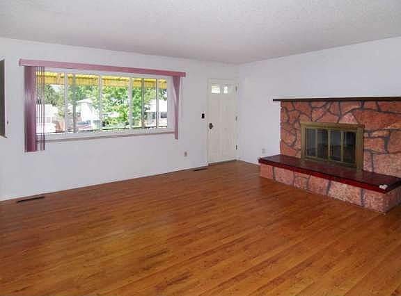 Living Room with laminate wood flooring, wood burning fireplace, and walk out 