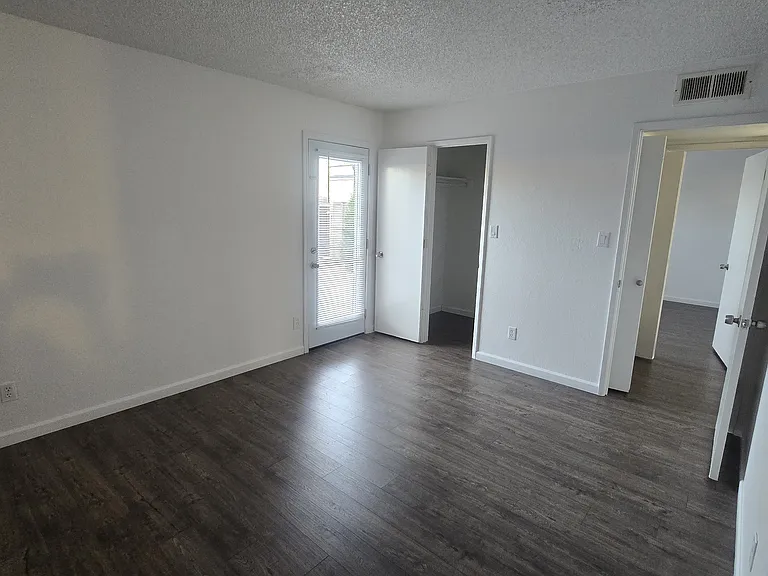 Master bedroom with walk in closet, on suite bathroom and exit to backyard.