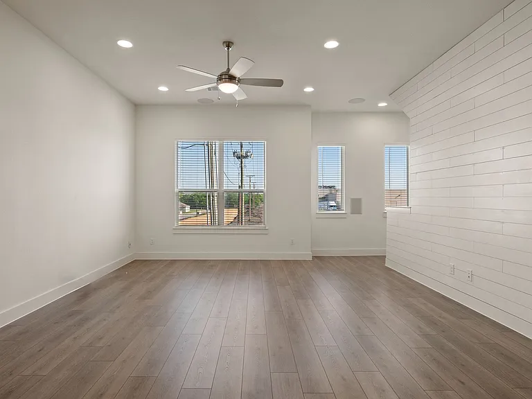 Living room with ceiling fan, gorgeous recessed lighting and multiple windows for great views and lots of natural light!