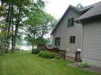 Side of home where large wrap around deck continues to the back of the garage