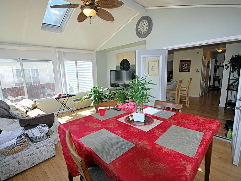Here is a photo of the furnished four-season sunroom. All the windows open to let in plenty of natural light and fresh air, and the room can also be fully closed off for privacy or comfort. This room offers a clear view of the backyard.