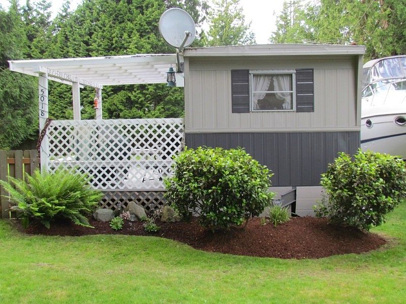 Cute, cute, cute!  510 sq ft single wide with covered front porch on large, flat lot only steps to the beach!