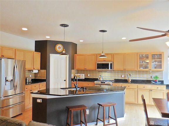 Recently upgraded kitchen with slab granite counters, full height backsplash, SS appliances, hardwood floors, lots of counter & cabinet space & more!