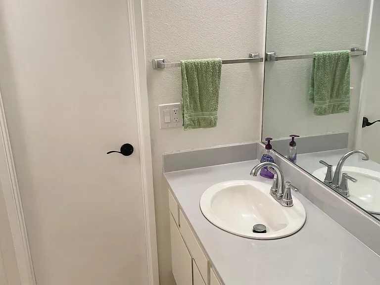 Bathroom sink and vanity in adjoining room.