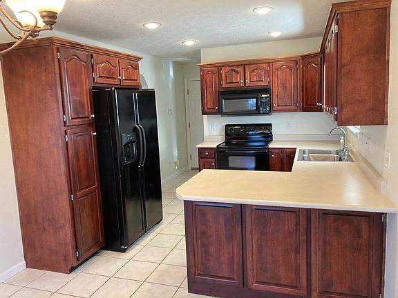 Custom cherry cabinetry is found throughout the home. Kitchen includes refrigerator, stove, dishwasher, built-in microwave and disposal.