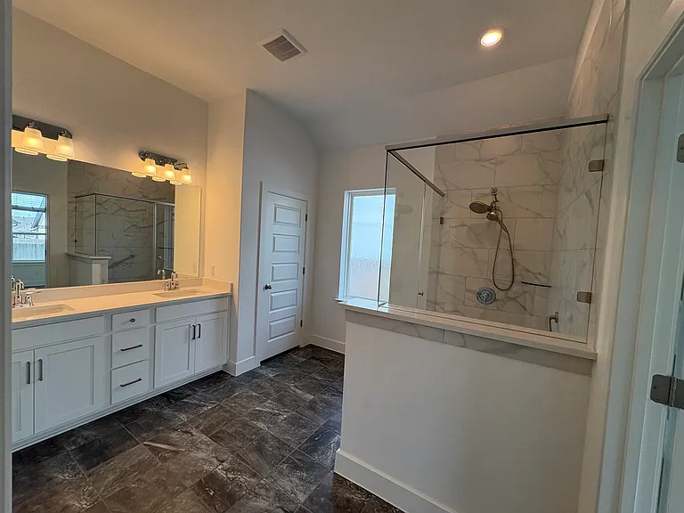 Primary bath with walk in shower, double vanity, huge shared walk in closet, linen closet with floor to ceiling shelving and toilet closet.